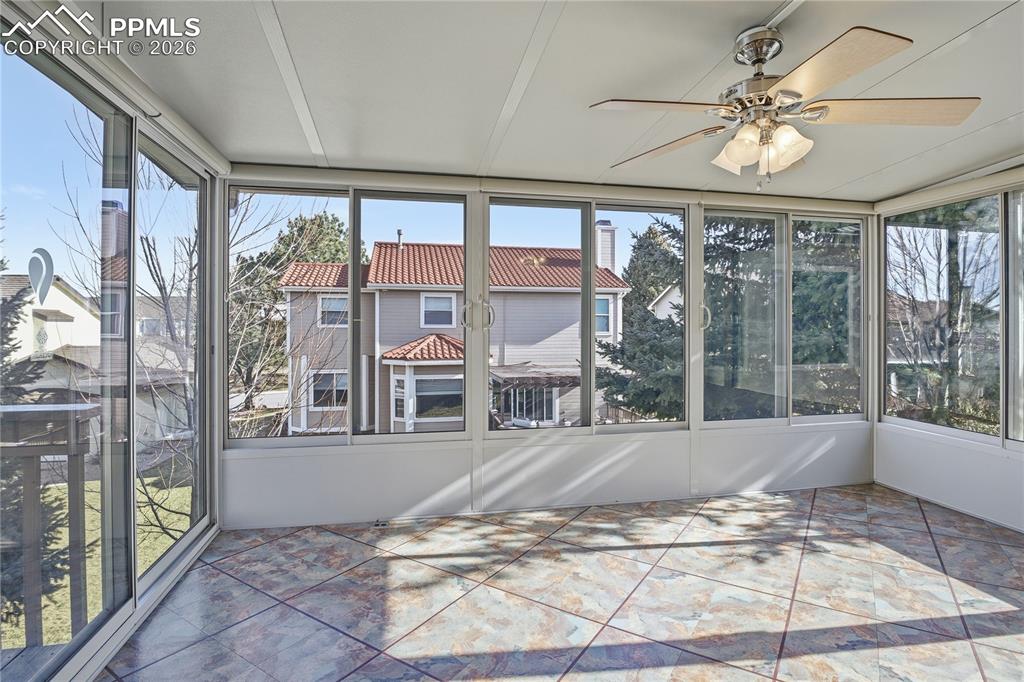 Unfurnished sunroom featuring ceiling fan