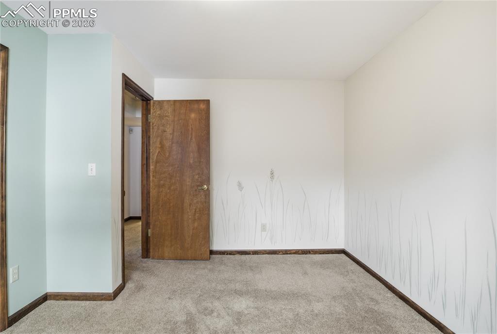 Empty room featuring carpet flooring and baseboards