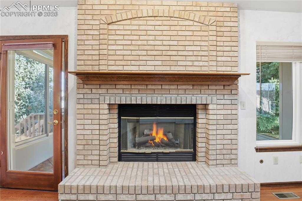 Detailed view of wood finished floors and a fireplace