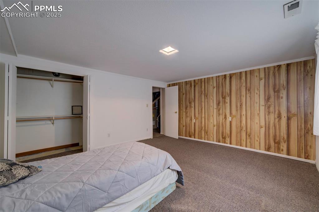 Basement Bedroom #3 with carpet and paneled wall.