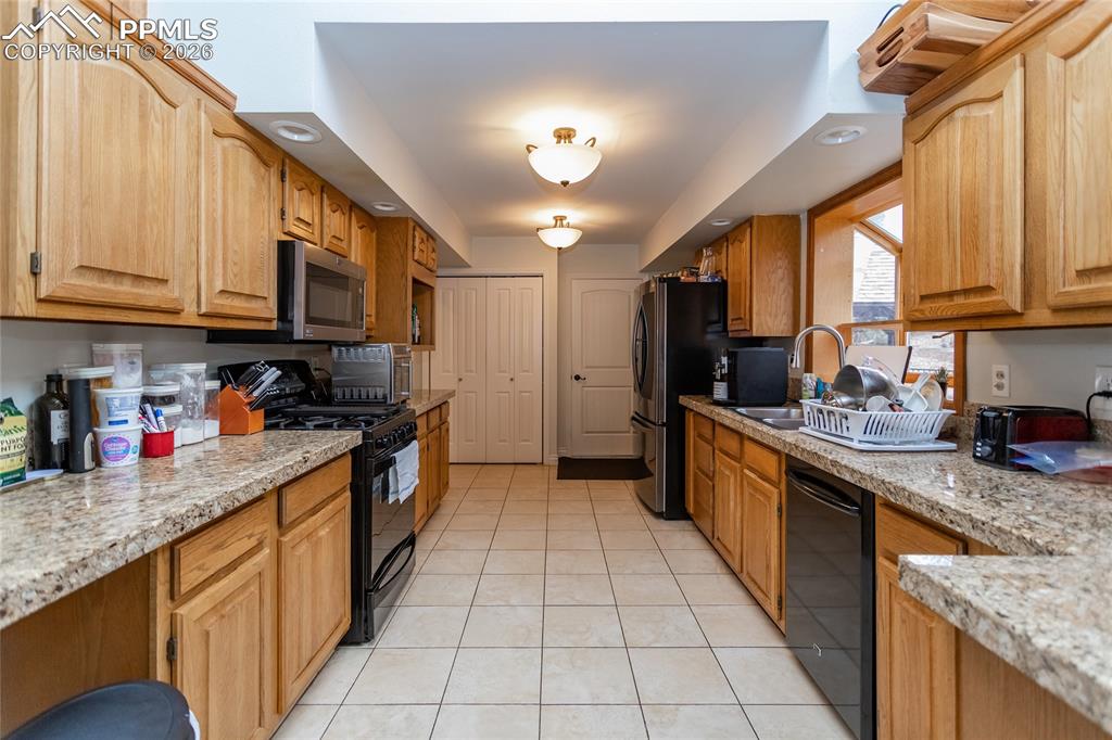 Spacious kitchen with stainless steel appliances (including gas stove), raised panel oak cabinets, tile floors, granite countertops & large pantry. 