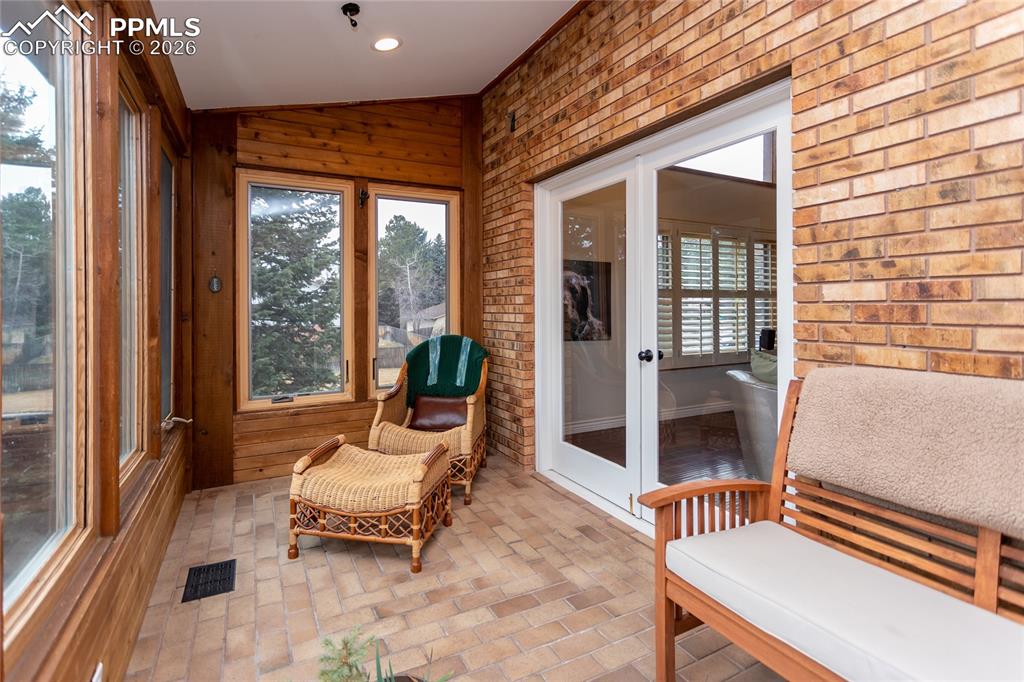 Cozy, light filled sun room with floor to ceiling windows accessed from the living room or the dining room with beautiful French doors.