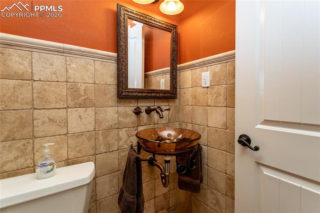 1/2 Bath on Main Level with beautiful tile & glass sink.