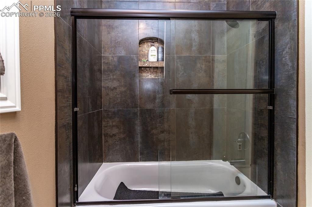 Roomy tub with shower & beautiful tile in the primary bath.