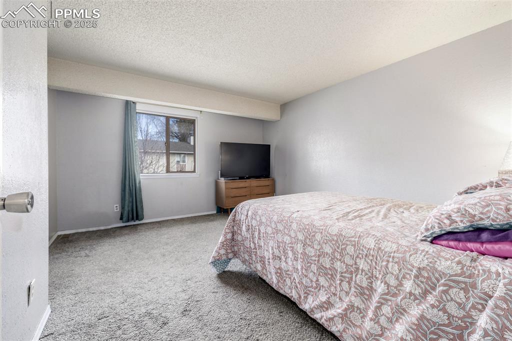 Bedroom featuring carpet flooring and a textured ceiling
