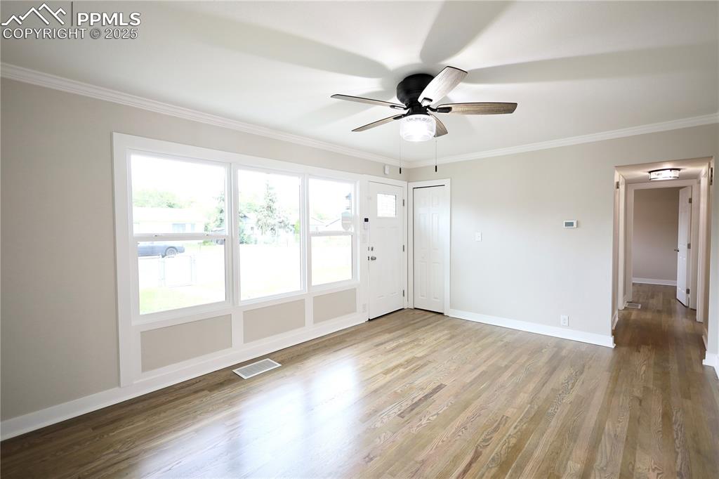 Spare room featuring ornamental molding, wood finished floors, and ceiling fan