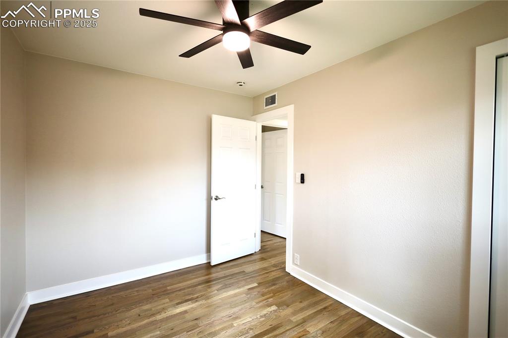 Unfurnished bedroom featuring wood finished floors and ceiling fan