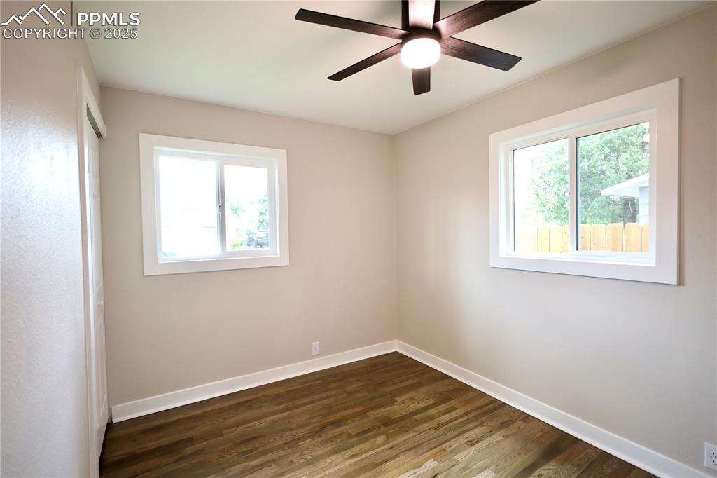 Spare room with dark wood finished floors and a ceiling fan