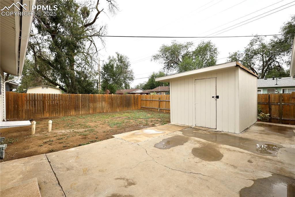 Fenced backyard with a patio and a storage shed