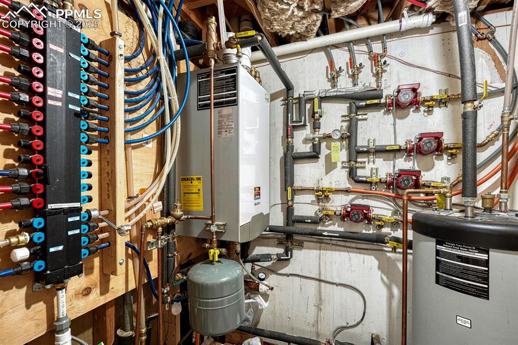 Mechanical room showing PEX plumbing, gas-fired boiler for radiant floor heat on upper level, and water heater
