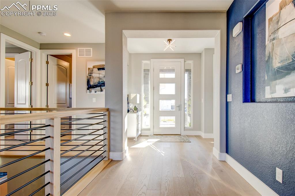 Entrance foyer with light wood-type flooring and recessed lighting
