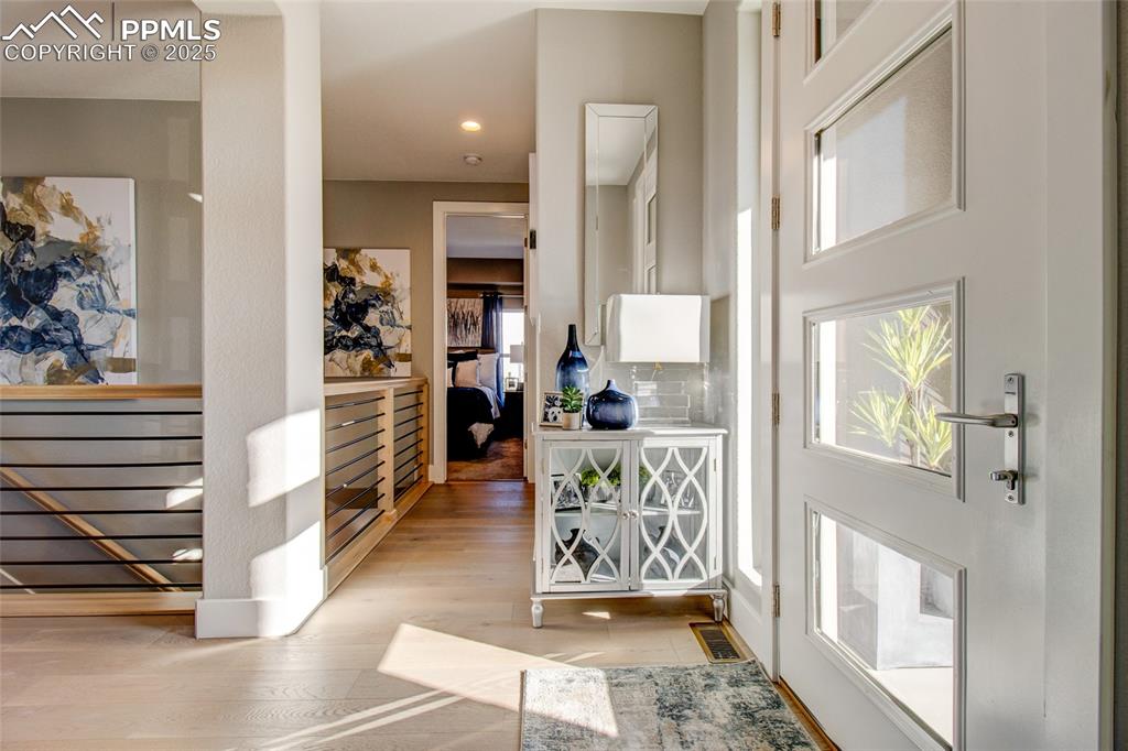Foyer entrance with light wood-style floors and recessed lighting