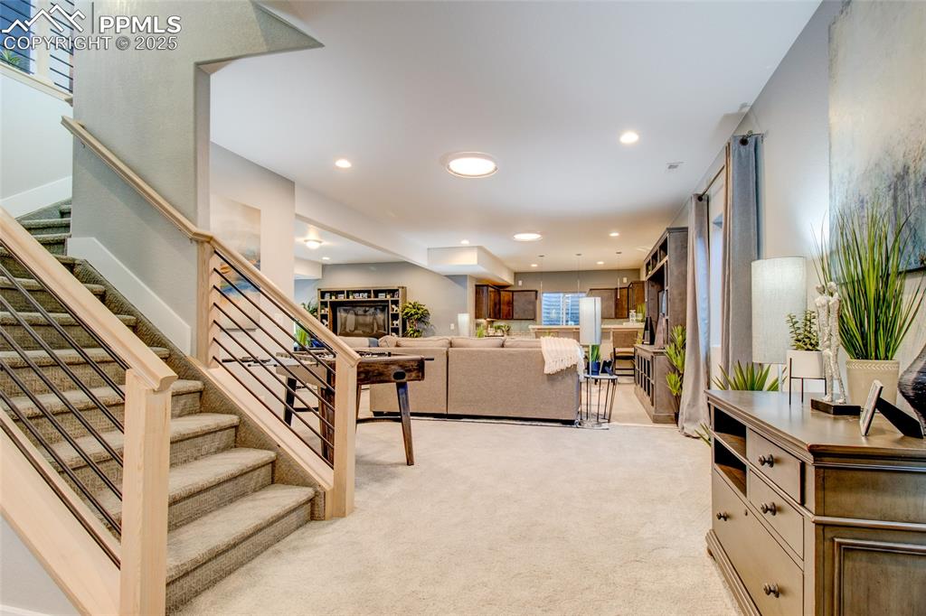 Living room featuring light carpet, stairway, and recessed lighting
