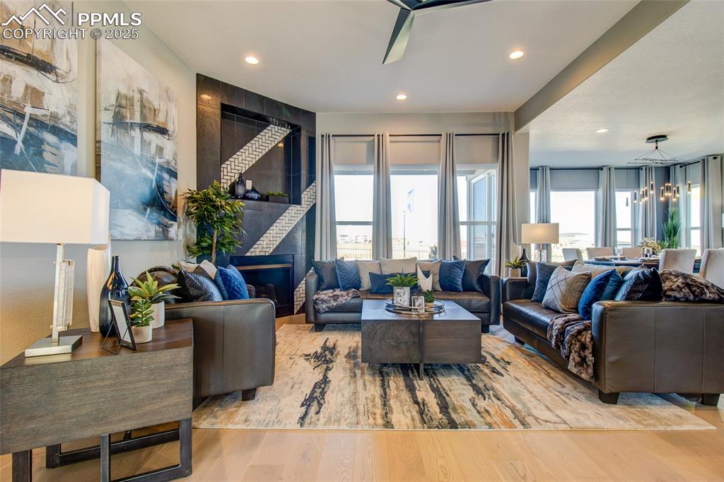 Living area with wood finished floors, recessed lighting, a chandelier, and a fireplace