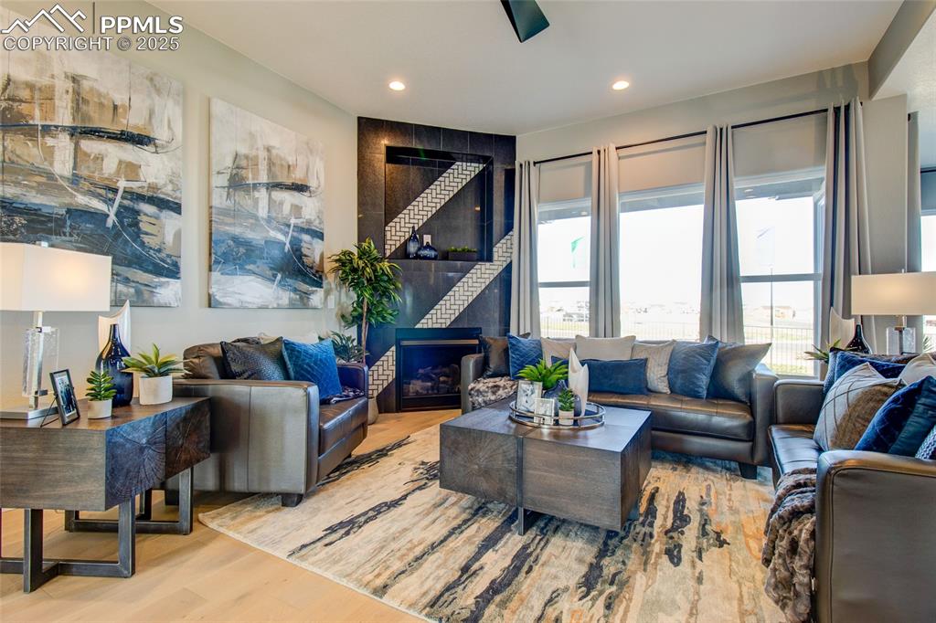 Living area with wood finished floors, recessed lighting, and a fireplace