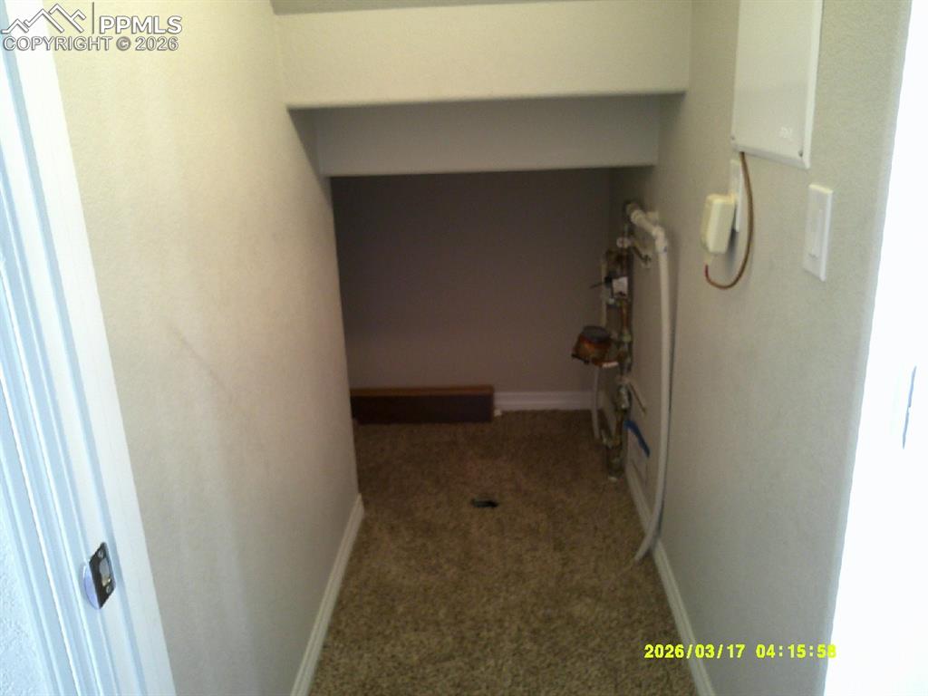 Hallway featuring carpet and baseboards