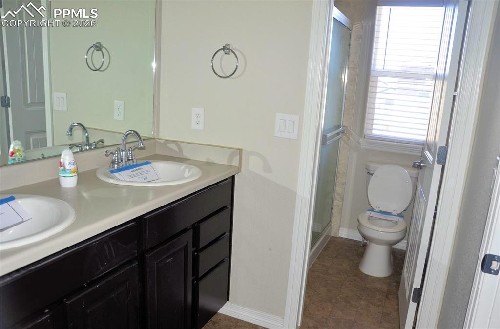Bathroom featuring double vanity and a shower stall