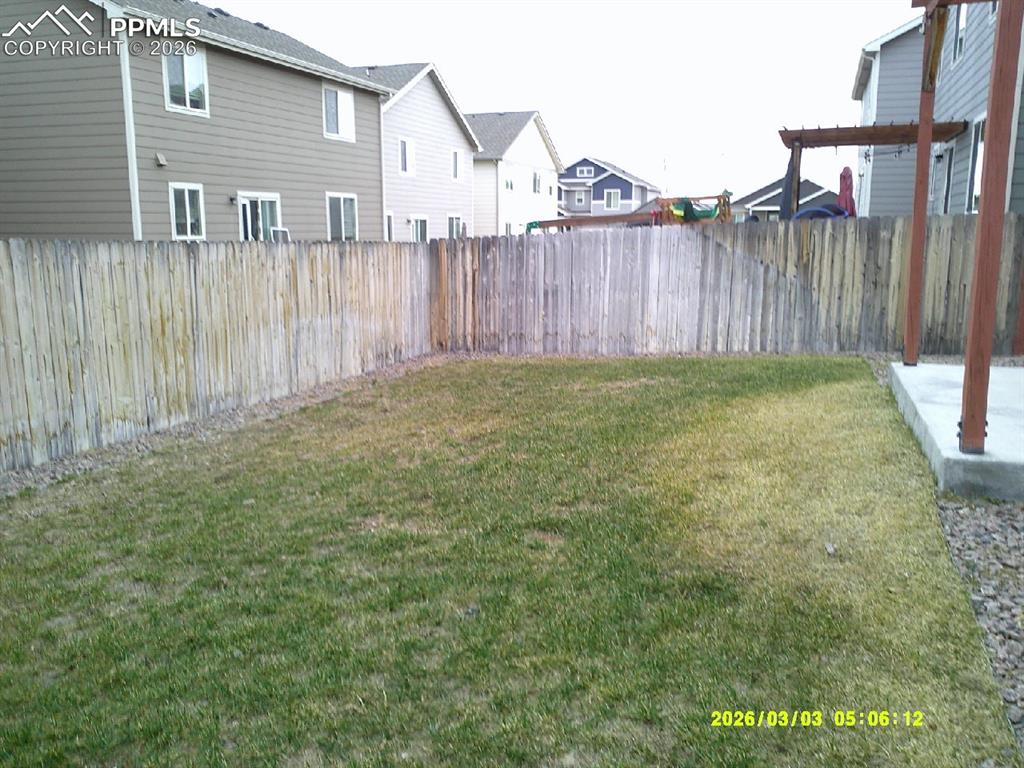 Fenced backyard featuring a residential view