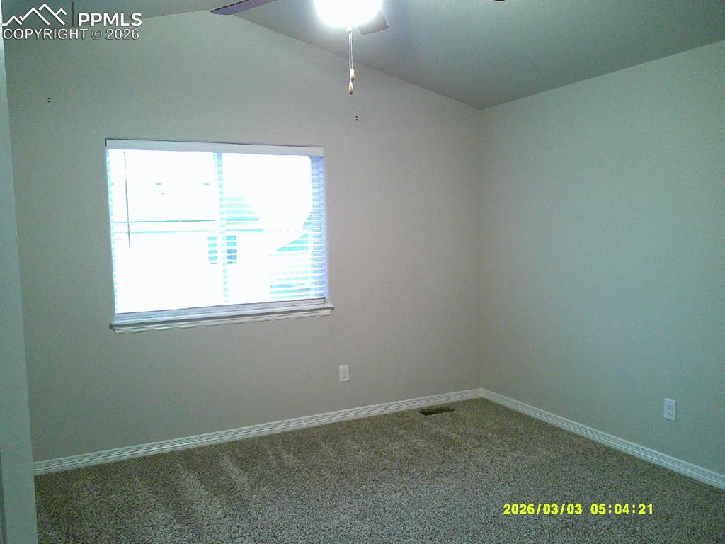 Spare room with dark carpet and ceiling fan