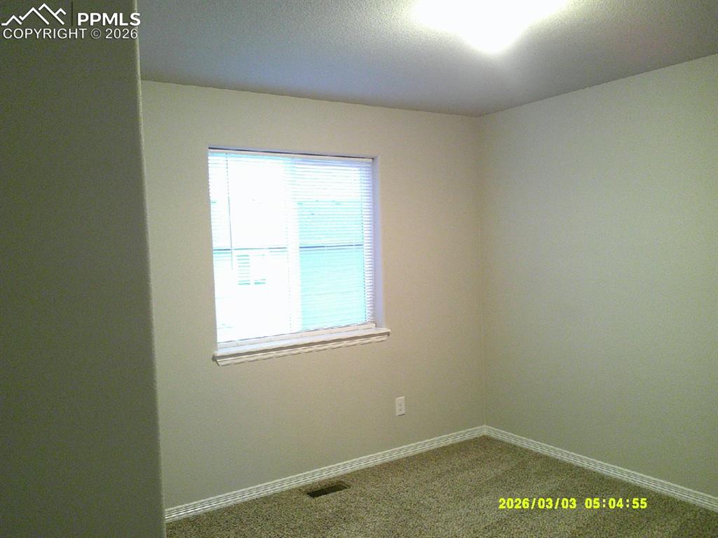 Unfurnished room with carpet and baseboards
