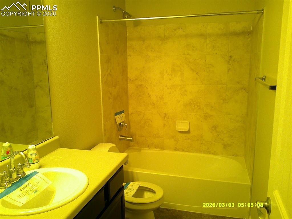Bathroom featuring vanity, a textured wall, and shower / washtub combination