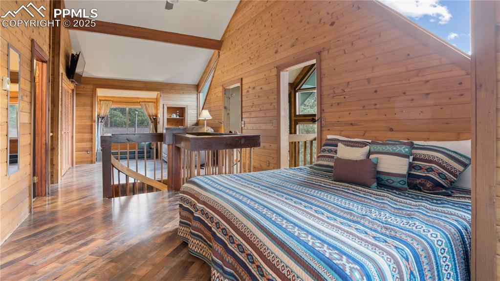 Bedroom featuring wood walls and wood finished floors