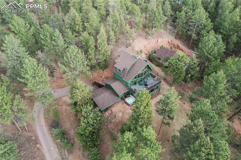 Aerial view of property's location with a heavily wooded area