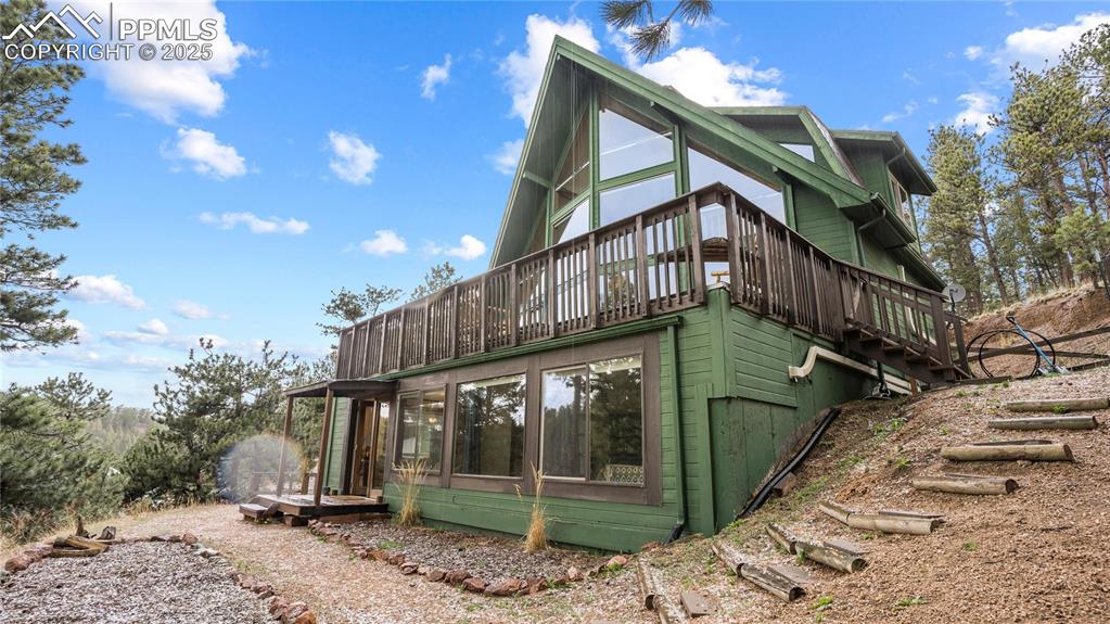View of property exterior with a wooden deck and stairs