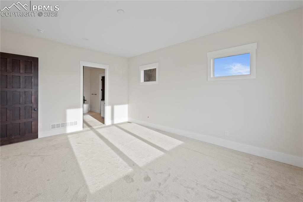 Unfurnished bedroom with carpet floors, baseboards, and visible vents