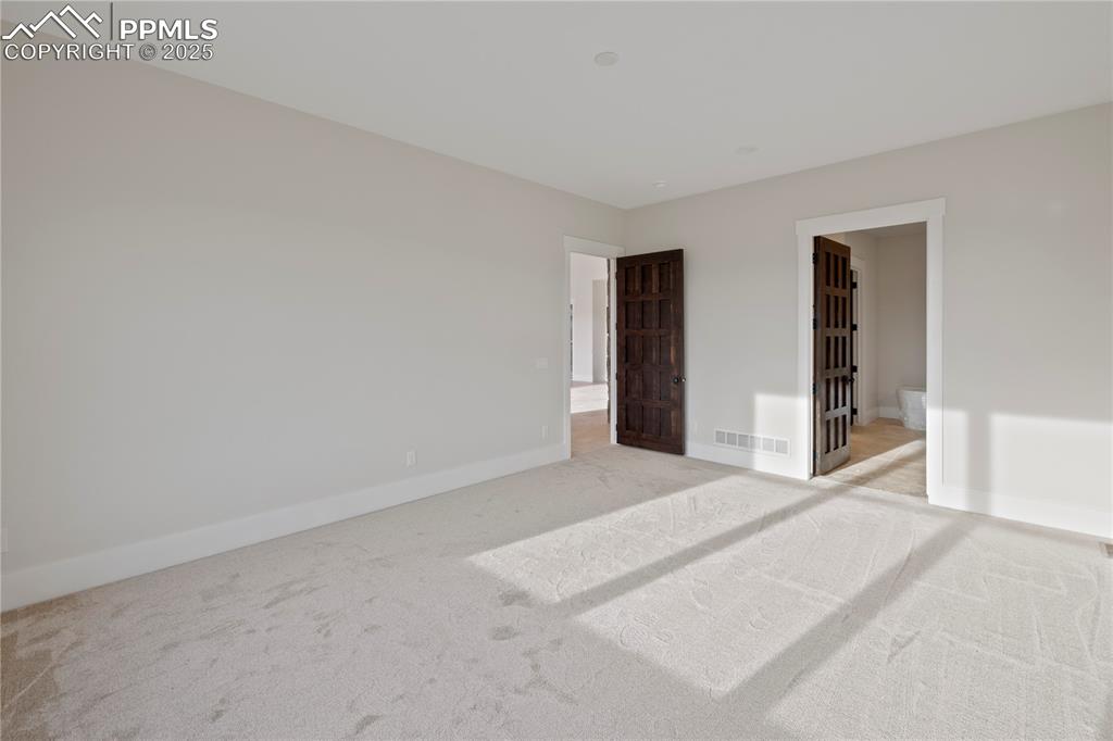 Unfurnished bedroom with light carpet, baseboards, and visible vents