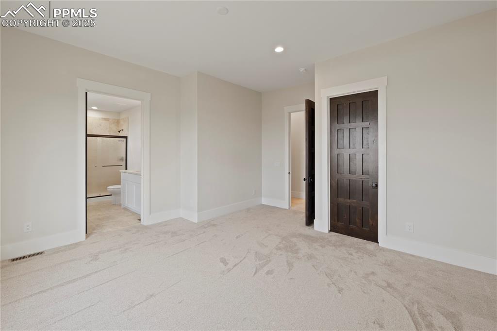 Unfurnished bedroom with visible vents, baseboards, connected bathroom, recessed lighting, and light colored carpet