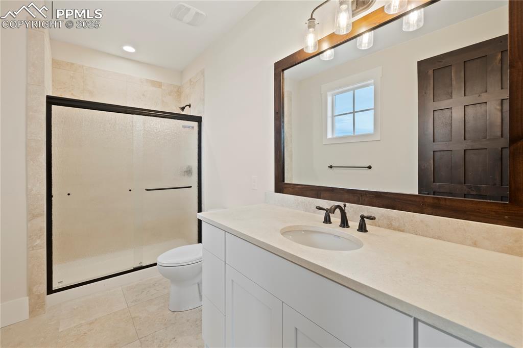 Bathroom with vanity, toilet, tile patterned floors, and a shower stall