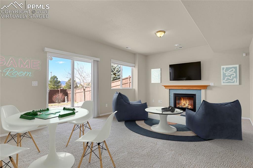 Lower level family room with gas fireplace. Virtually Staged
