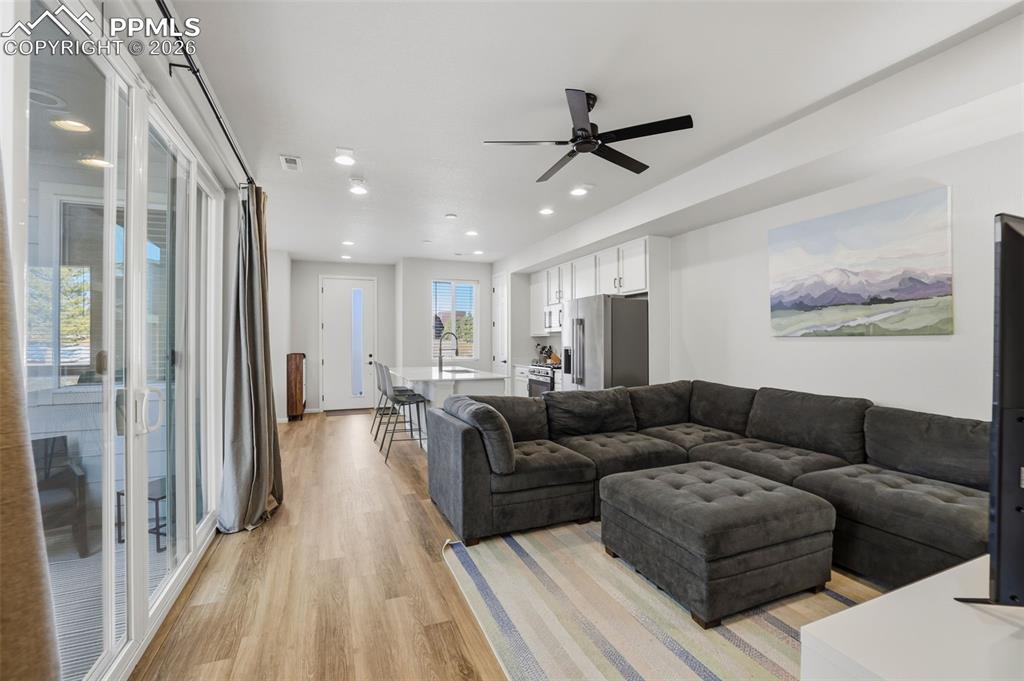 Living area featuring light wood finished floors, recessed lighting, and a ceiling fan