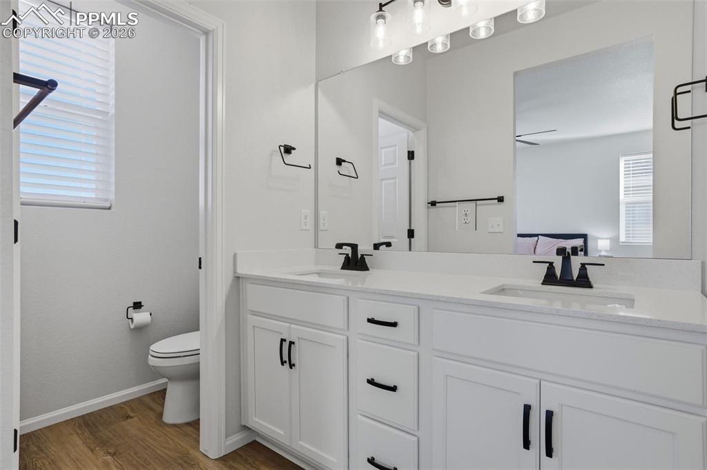 Bathroom with double vanity and light wood-type flooring