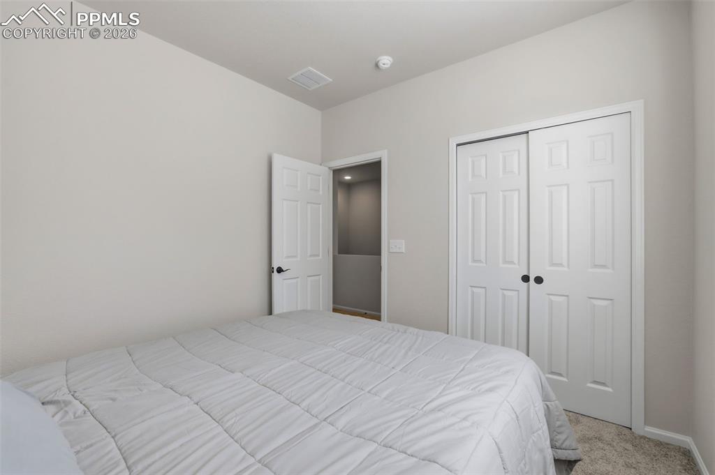 Carpeted bedroom featuring a closet and baseboards