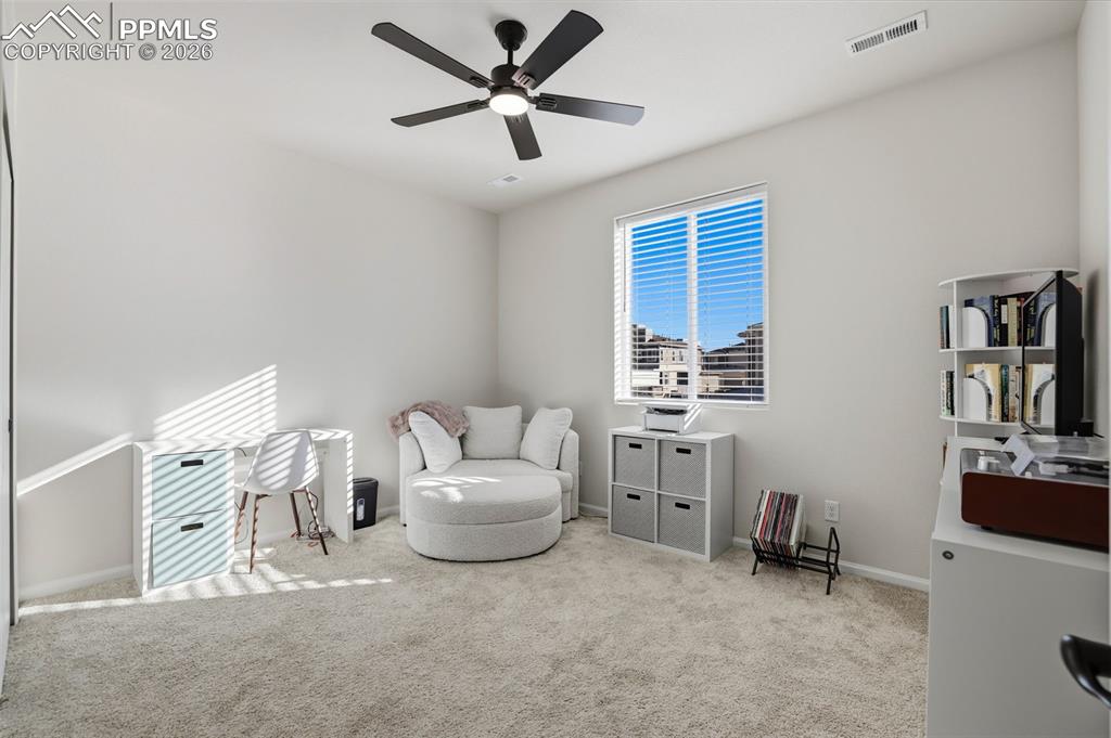 Living area with carpet flooring and a ceiling fan