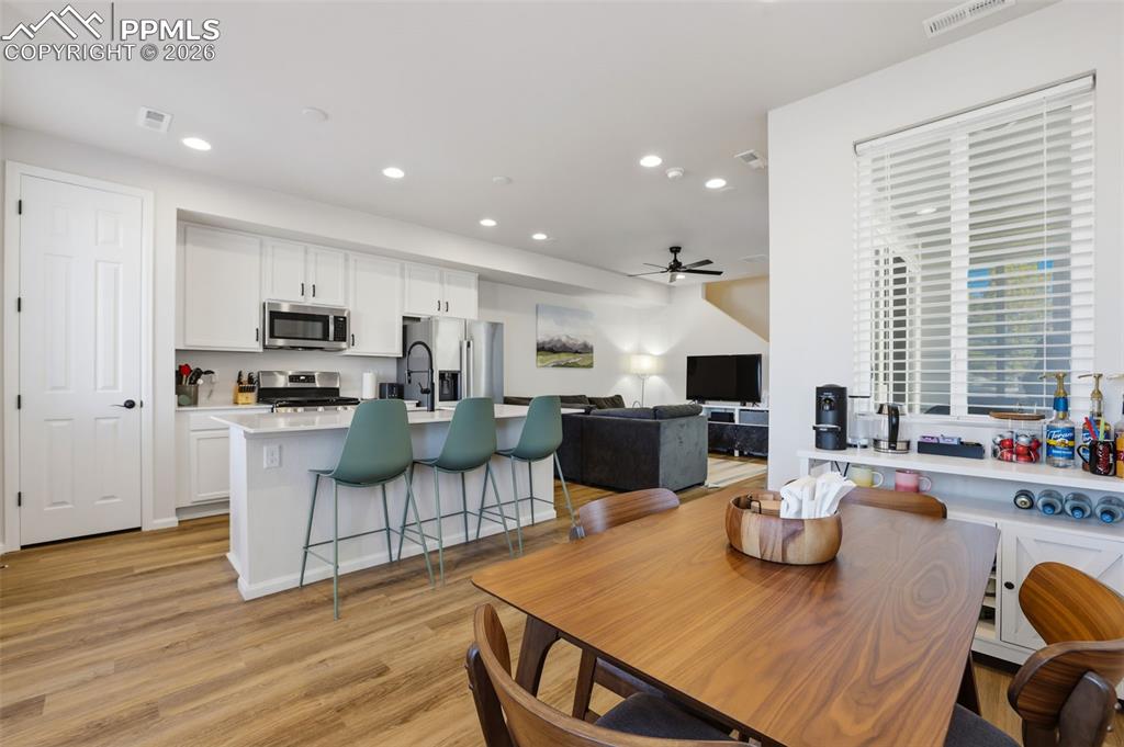 Dining room with recessed lighting, a ceiling fan, and light wood-style flooring