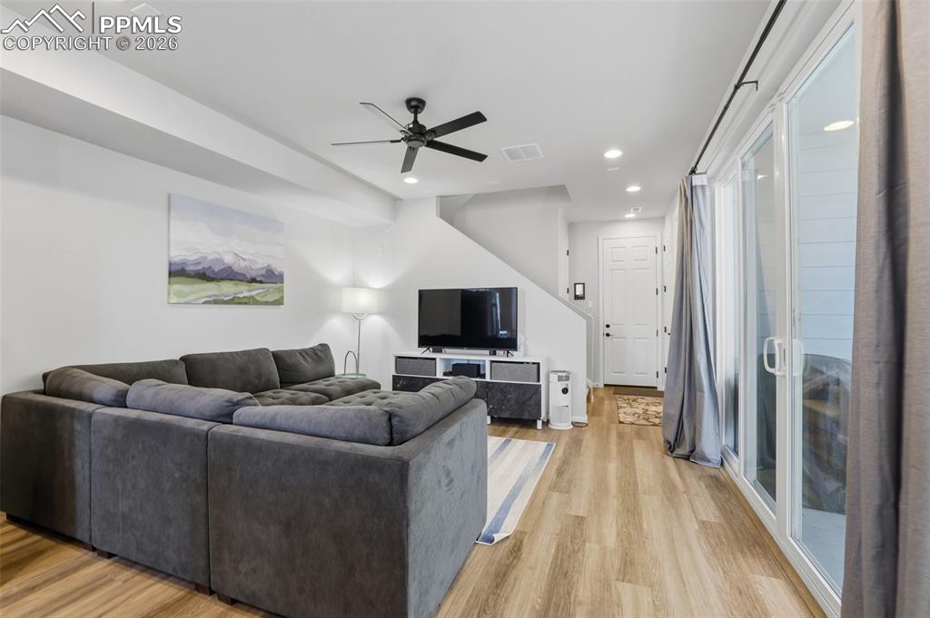 Living area featuring a ceiling fan, light wood-style floors, and recessed lighting