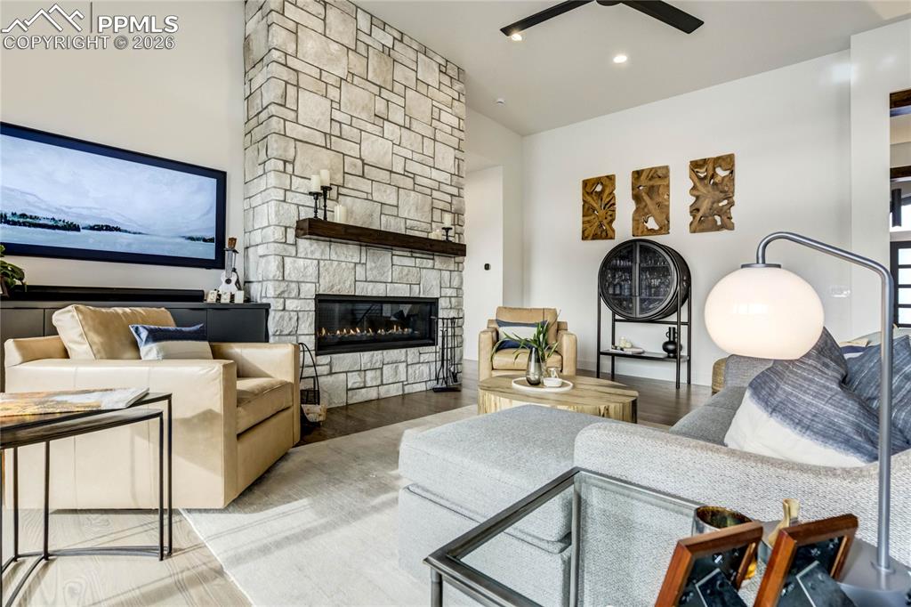 Defined by volume and light with hardwood floors, soaring ceilings and a commanding floor-to-ceiling stone modern fireplace framed by an alder mantle 