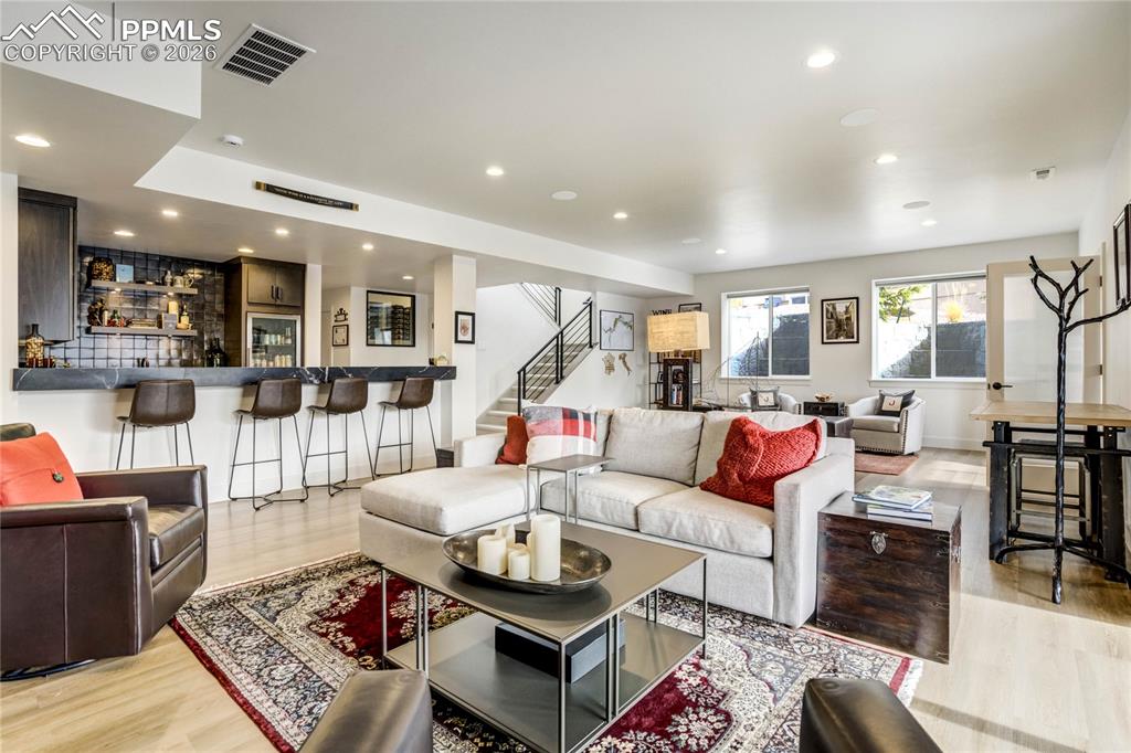 The walk-out lower level continues the architectural narrative with 9’ ceilings, surround sound, and a statement wet bar finished in honed granite with a substantial 6-inch edge.