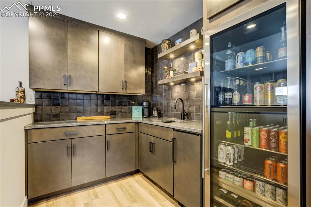 Thoughtfully Designed for Elevated Entertaining, the Bar Features Honed Black Mist Granite Countertops with a Substantial Six-Inch Thick Edge, Matte Black Fixtures, Beverage Refrigerator, and Ice Maker. Under-Cabinet Lighting and Dimmable Overhead Illumination Create Layered Ambiance, While Integrated Surround Sound Completes the Experience—Transforming the Space into a True Gathering Destination