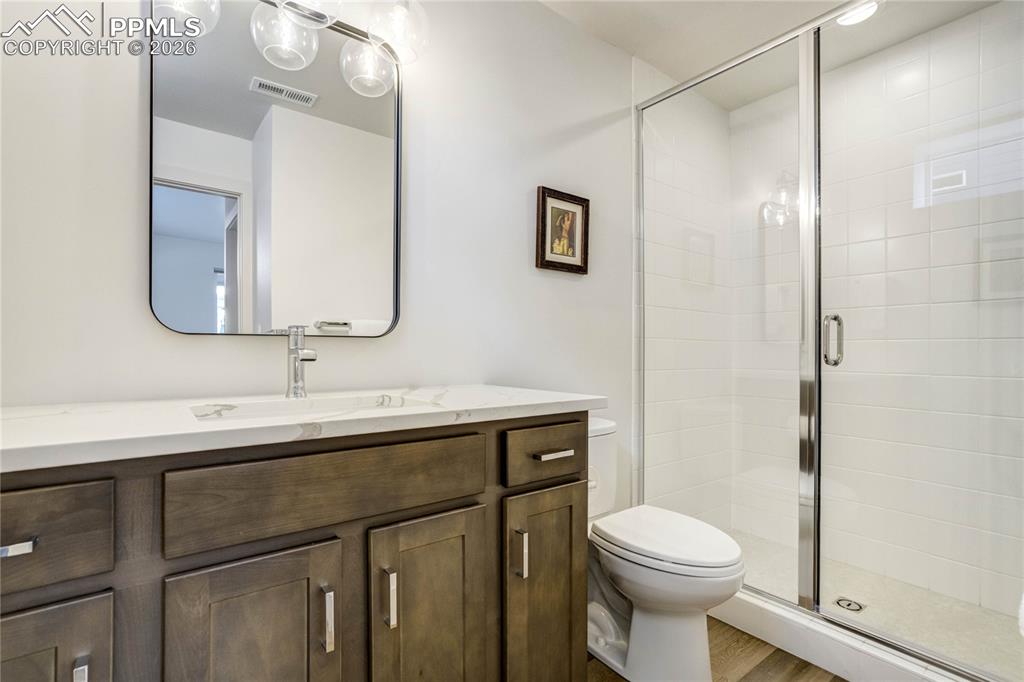  The Jr. Suite's Private Ensuite Bath Features Quartz Countertops, a Walk-in Shower with Refined Tile Finishes and Bench Seating, Delivering Elevated Accommodations that Mirror the Quality and Design Carried Throughout the Home