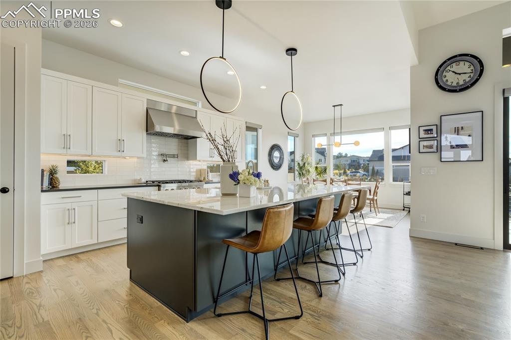 At the Center of the Home, the Kitchen Becomes a Natural Gathering Place—Where Design and Function Converge. A 10’ Crystal Spectrum Quartzite Island Anchors the Space with Quiet Confidence, its Surface Reflecting Both Light and Movement. Honed Cardozo Black Quartzite Frames the Perimeter, Adding Contrast and Depth Against the Two-Toned Soft Close Cabinetry in Crisp White and Rich Iron Ore. 