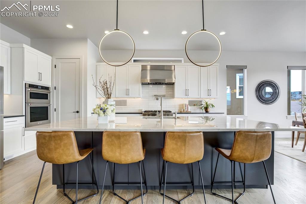 Complemented by Wall Oven, Microwave, Dishwasher, and Bosch Wi-Fi Enabled Refrigerator. Under-Cabinet Lighting Casts a Soft Glow Across the Workspace, While a Custom Walk-in Pantry with Wood Shelving + Tech Drawer Keeps the Aesthetic Clean and Composed. It is a Space Designed Not Only for Cooking—but for Conversation, Connection + Everyday Luxury