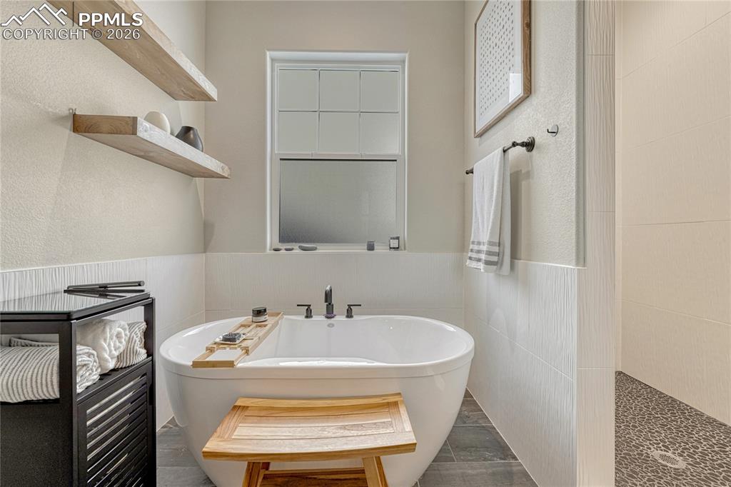 relaxing soaking tub with large walk-in shower in primary en suite