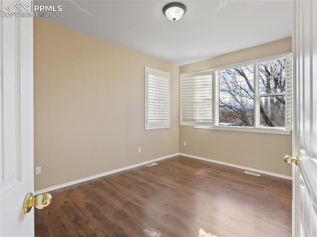 Officewith dark wood-style flooring and baseboards