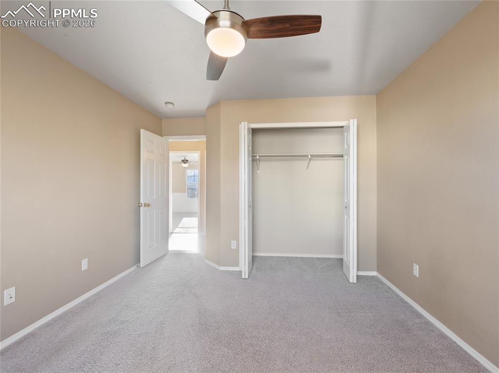 Unfurnished bedroom with a ceiling fan, light colored carpet, and a closet