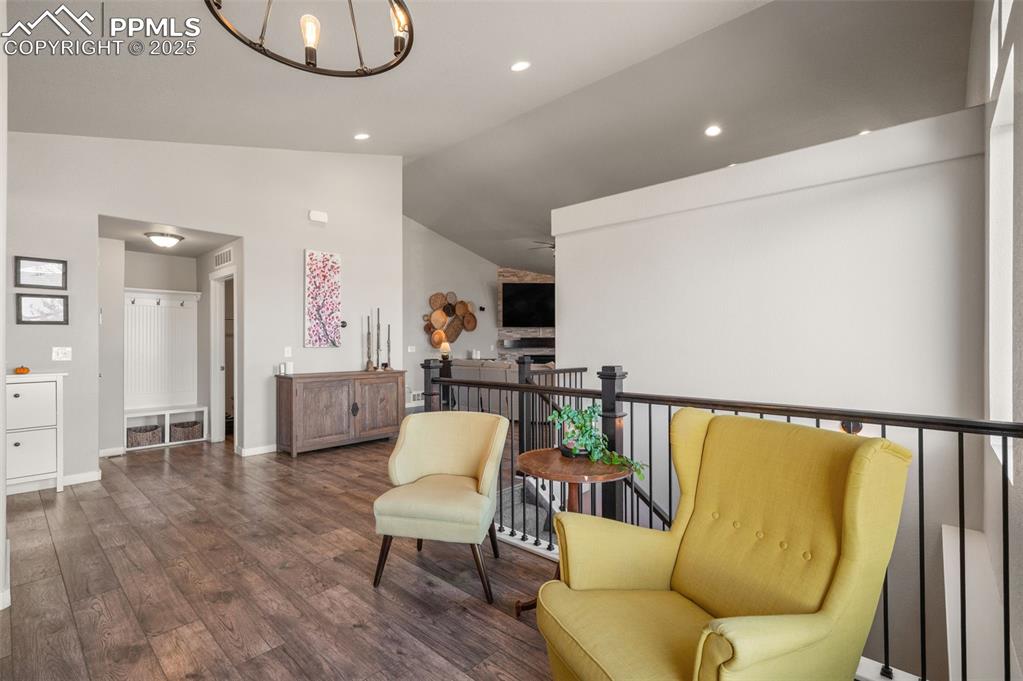 Living area featuring lofted ceiling, a chandelier, dark wood finished floors, and recessed lighting