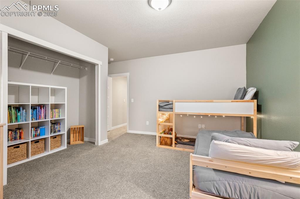 Carpeted bedroom with baseboards and a closet